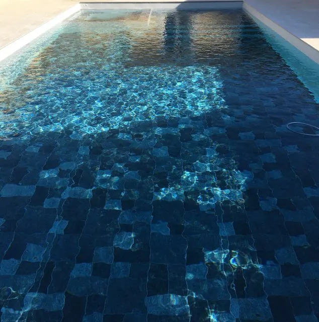 Reflets de l’eau sur un revêtement mosaïque bleu.