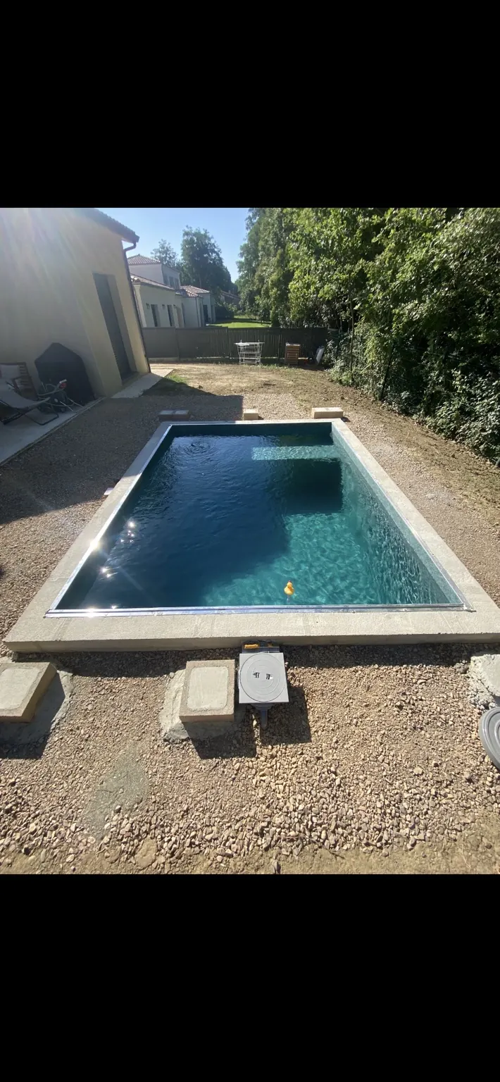 Petit bassin rectangulaire en eau avec escalier intérieur.
